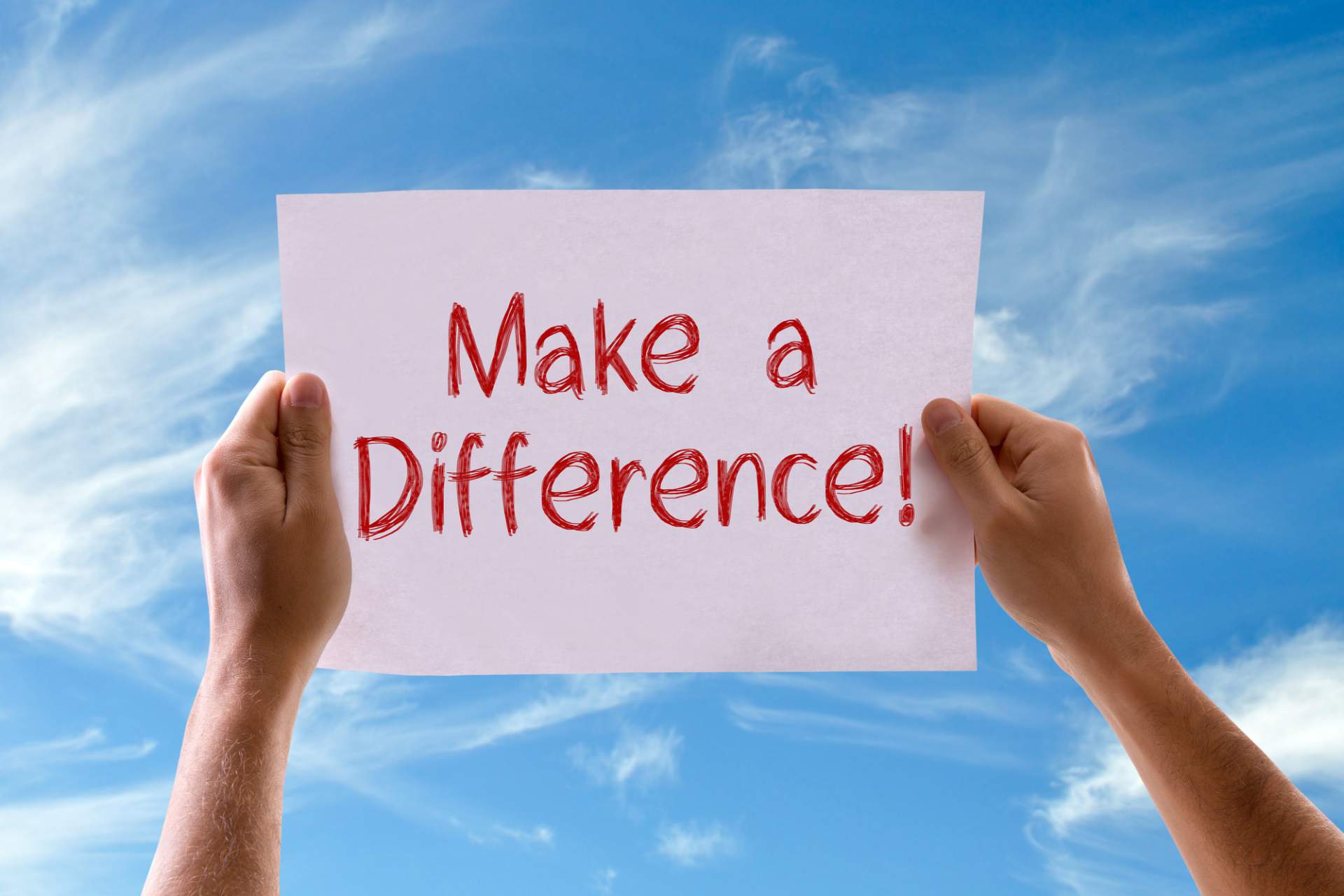 Hands holding a sign that says, 'Make a Difference'