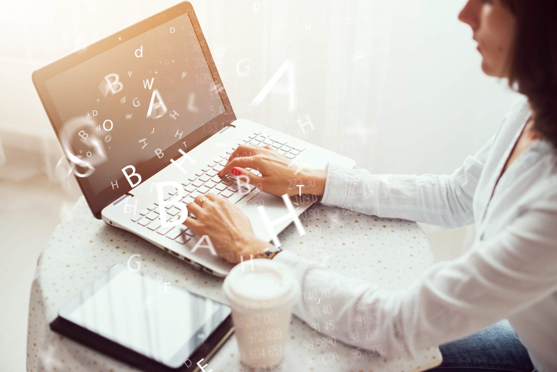 Woman typing on laptop with letters coming off screen